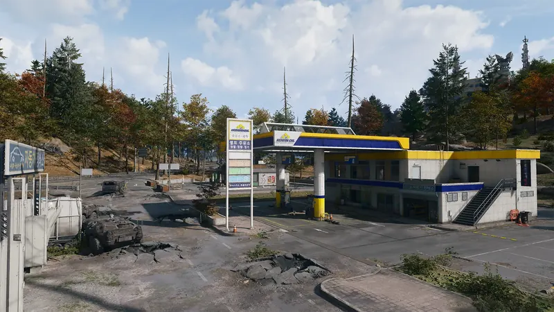 Korin Oil gas station with a yellow and blue canopy, damaged roads, and abandoned military vehicles.